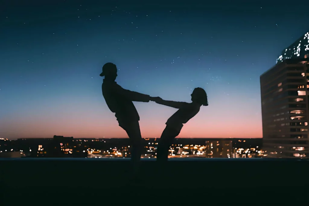 A couple holding hands on the roof of the skyscraper